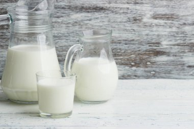 Beyaz ahşap tahtalarda farklı süt ürünleri