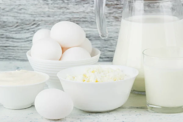 Different dairy products on the white wooden boards — Stock Photo, Image