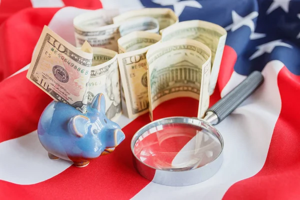 Збільшувальне скло і американських доларів на державному прапорі США, фону — стокове фото