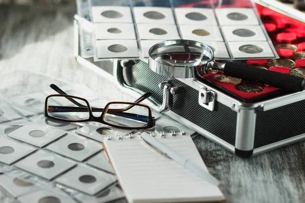 Different old collector's coins and banknotes with a magnifying glass — Stock Photo, Image