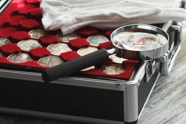Різні колекційні монети в коробці зі збільшувальним склом і білими рукавичками — стокове фото