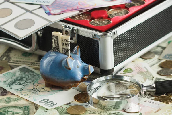 Farklı sikke ve banknot bir büyüteç ve kumbara — Stok fotoğraf