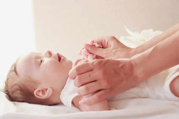 Baby och händer mamma, inomhus, suddig bakgrund — Stockfoto