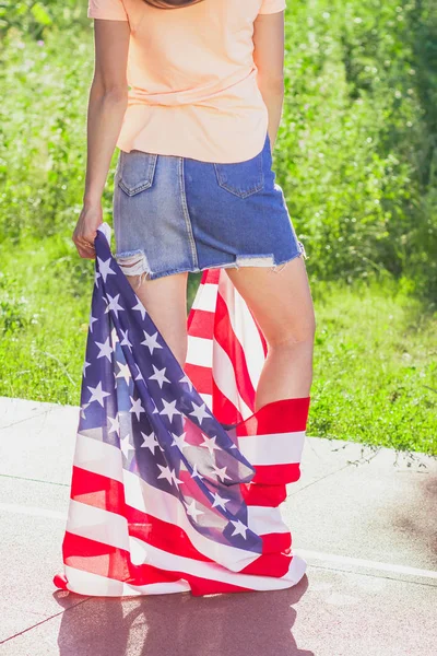 Mujer con una bandera de Estados Unidos de América en las manos, al aire libre —  Fotos de Stock