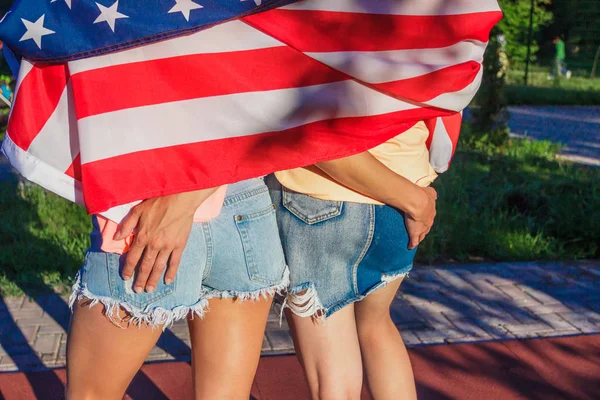 Duas meninas bonitas com bandeira americana, ao ar livre, fundo borrado — Fotografia de Stock