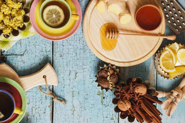 Κούπες με τσάι από βότανα και τα κομμάτια του λεμονιού, αποξηραμένα βότανα και διαφορετικές διακοσμήσεις — Φωτογραφία Αρχείου