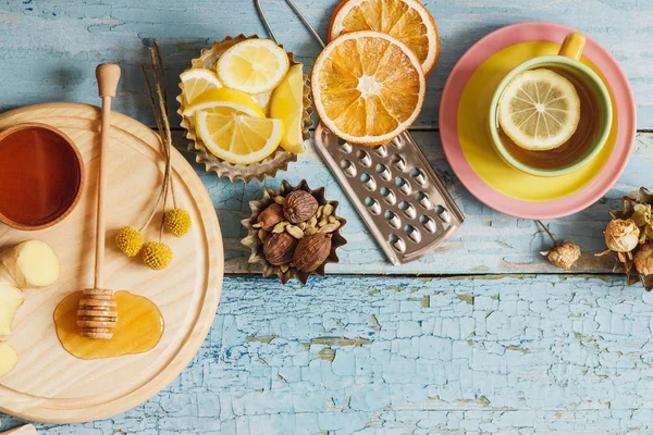 Tazas con té de hierbas y trozos de limón, hierbas secas y diferentes decoraciones —  Fotos de Stock