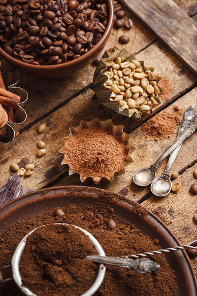 Roasted black and green coffee beans and ground coffee in the plate
