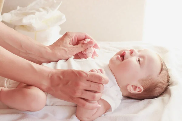 Dziecko i ręce matki, wewnątrz, niewyraźne tło — Zdjęcie stockowe