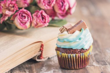 Dekorasyon ile el yapımı çikolatalı kekler. Kitap ve bir buket gül