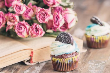 Dekorasyon ile el yapımı çikolatalı kekler. Kitap ve bir buket gül