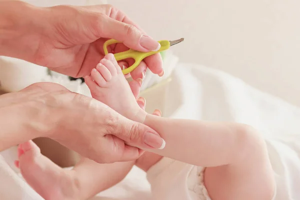 Baby och händer mamma med en baby sax, inomhus, suddig bakgrund — Stockfoto