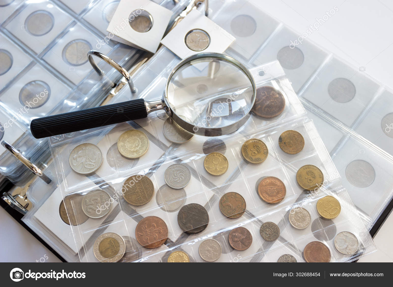 Different old collector's coins with a magnifying glass, blurred background  Stock Photo by ©lisssbetha@gmail.com 302688454