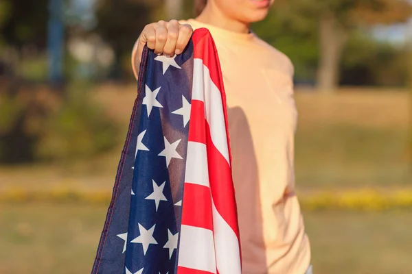 Mujer con bandera de Estados Unidos de América en la mano, al aire libre —  Fotos de Stock