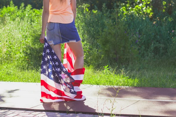 Žena s vlajkou Spojených států amerických v rukou venku — Stock fotografie