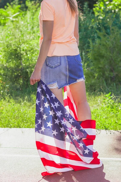 Žena s vlajkou Spojených států amerických v rukou venku — Stock fotografie