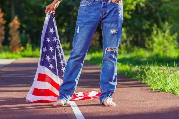 Mujer con una bandera de Estados Unidos de América en las manos, al aire libre —  Fotos de Stock