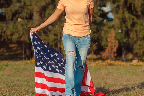 Kobieta z flagą Stanów Zjednoczonych Ameryki w ręku, na zewnątrz — Zdjęcie stockowe