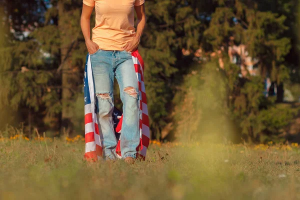 Mulher com uma bandeira de Estados Unidos da América na mão, ao ar livre — Fotografia de Stock