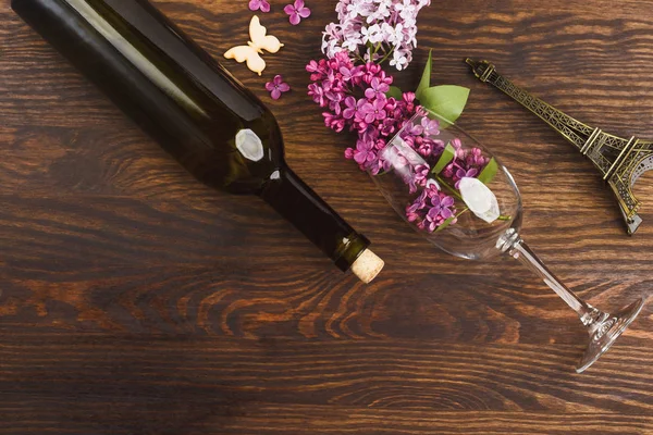 Bicchiere da vino con lillà e farfalle — Foto Stock