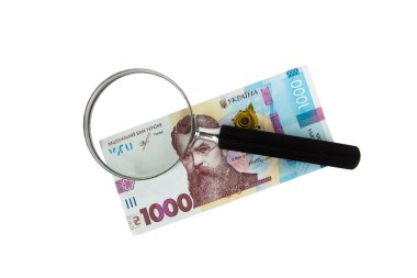 Beyaz arka planda 1000 hryvnia ve bir büyüteç.