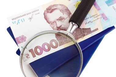 İki Ukrayna pasaportu, loupe ve bin hryvnia, beyaz üzerinde izole edilmiş.
