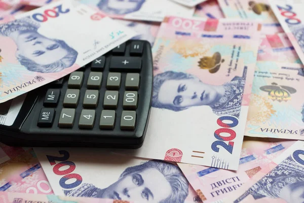 Hesap makinesi ve iş konsepti olan 200 hryvnianın arkaplanı