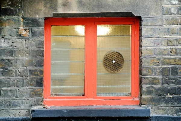 part of a building facade with small colored window