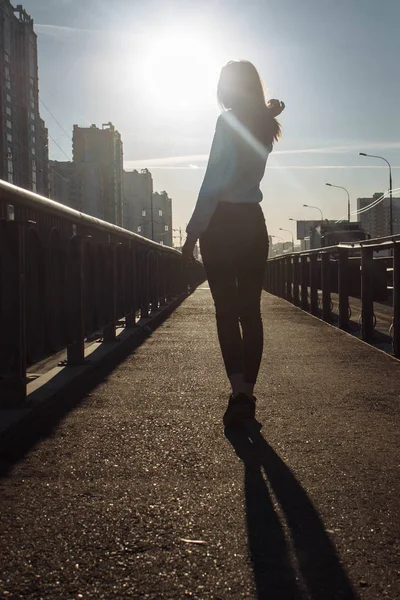 silhouette of a girl against the sun in the city