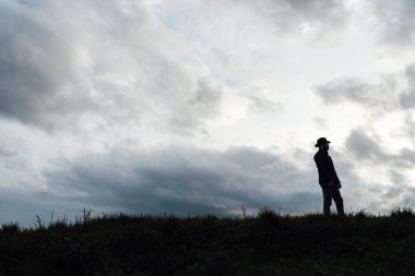 Eski avcı yürüyüşleri. Tüfek Avcısı Silhouetted in Beautiful Sunset or Sunrise. Avcı bataklıkta ve tarlada tüfeği hedefliyor