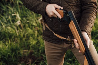 Eski avcı yürüyüşleri. Tüfek Avcısı Silhouetted in Beautiful Sunset or Sunrise. Avcı bataklıkta ve tarlada tüfeği hedefliyor