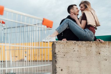 Genç, modaya uygun güzel bir çift alışveriş yapıyor ve market yakınlarında tramvaya binip eğleniyor.