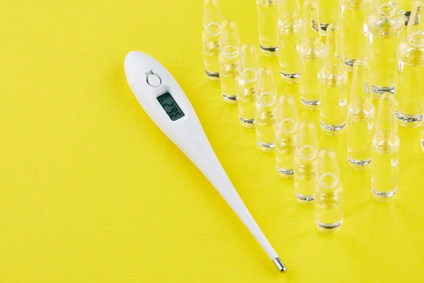 Thermometer Und Ampullen Mit Medikamenten Auf Gelbem Hintergrund — Stockfoto