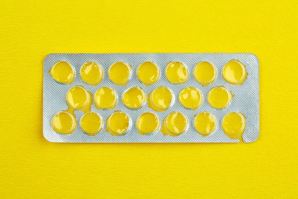 Boş bir paket tablet sarı zemin üzerine.
