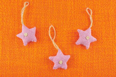 Yılbaşı ağacı süsleri turuncu kendir üzerinde yıldız şeklinde. Yeni yıl oyuncak