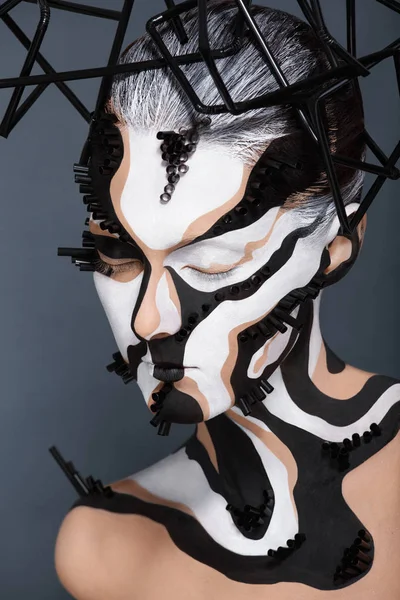 Female model with creative abstract makeup in futuristic hat