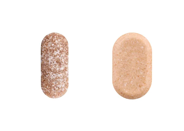 Två bruna ovala piller isolerade på vit bakgrund — Stockfoto
