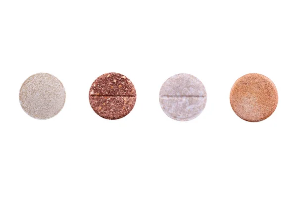 Fyra bruna piller isolerade på vit bakgrund. Medicin — Stockfoto