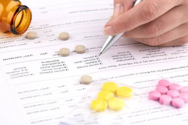 Renkli haplar, kahverengi şişe ve tıbbi formda el yazısı