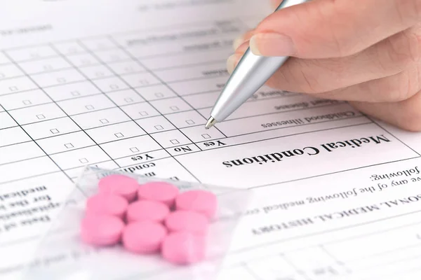 Pastillas rosadas y escritura manual en forma de cuestionario médico —  Fotos de Stock