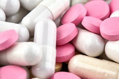 Beyaz kapsüller ve pembe hapların yakın çekim fotoğrafı
