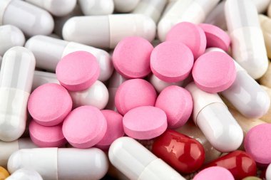 Beyaz kapsüller ve pembe hapların yakın çekim fotoğrafı