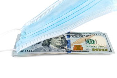 Mavi tıbbi yüz maskesi ve beyaz arka planda izole edilmiş 100 dolarlık banknotlar.