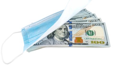 Mavi tıbbi yüz maskesi ve beyaz arka planda izole edilmiş 100 dolarlık banknotlar.
