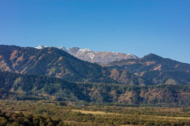 Dağ zirveleri ve mavi gökyüzü olan güzel bir manzara