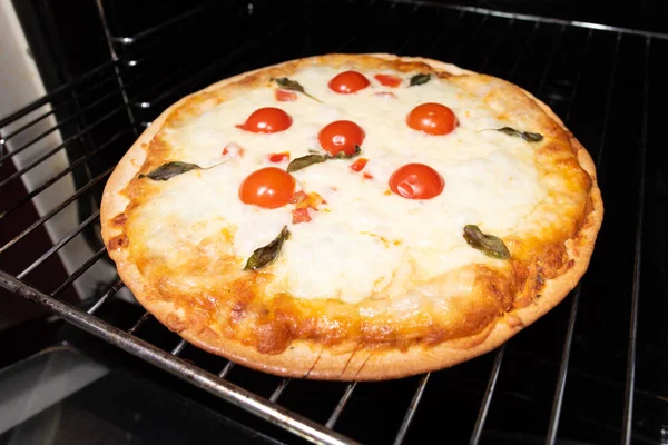 Pizza faire gros plan avec des tomates et du fromage du four — Photo
