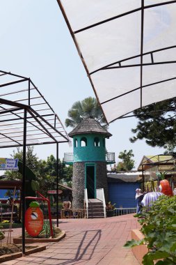 An artificial lighthouse that serves as a boat ride in a theme park