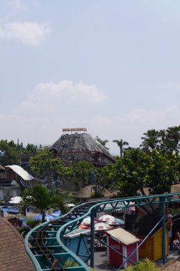 Suni bir dağın gündüz tema parkındaki bardak altlığı sürüşünün yeri olan yükseklikten görünüşü