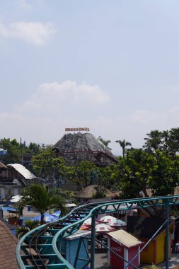 Suni bir dağın gündüz tema parkındaki bardak altlığı sürüşünün yeri olan yükseklikten görünüşü