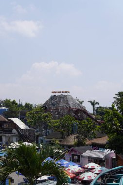 Suni bir dağın gündüz tema parkındaki bardak altlığı sürüşünün yeri olan yükseklikten görünüşü